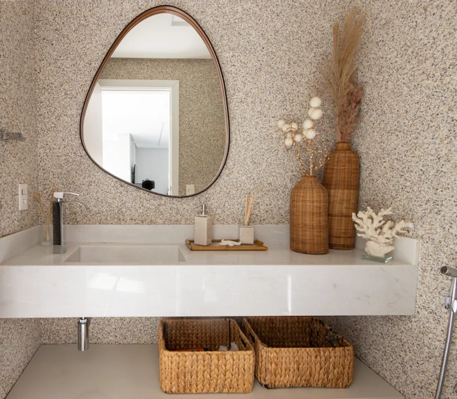 Lavabo com bancada em pedra e espelho orgânico