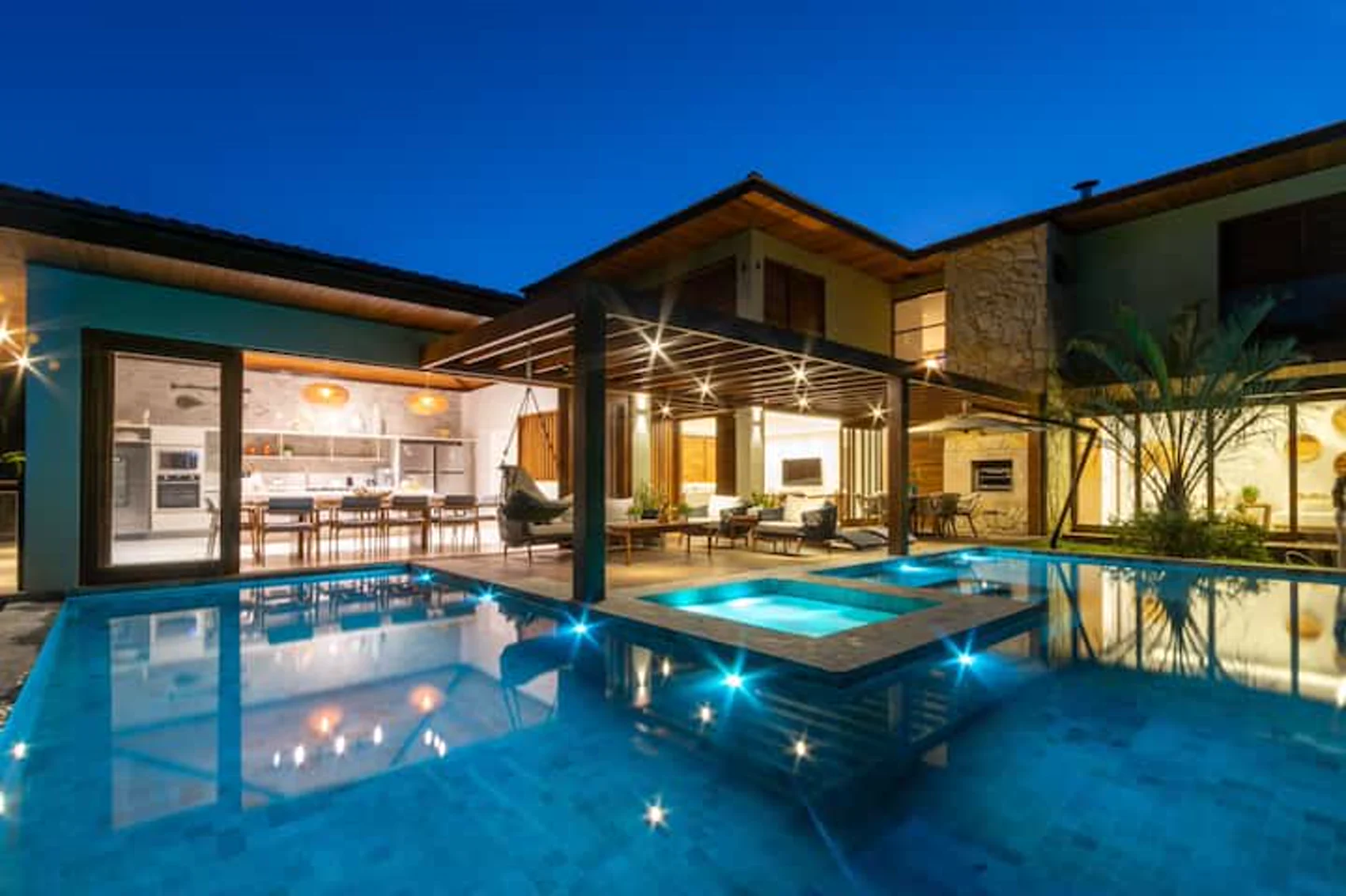 A piscina de borda infinita ao entardecer, com o céu em brasa